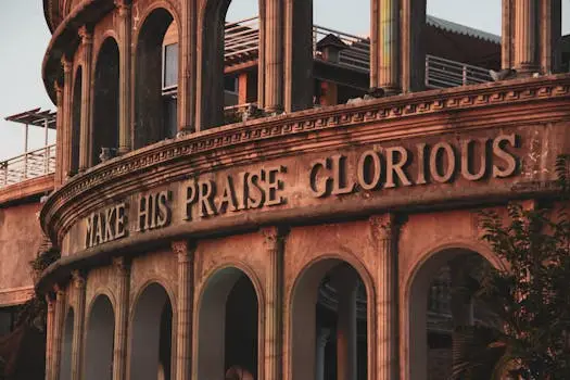 Elegant historic building facade with 'Make His Praise Glorious' inscription.